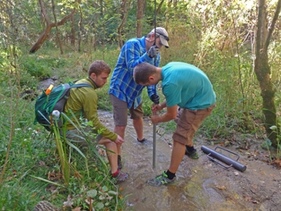 Marty D. Frisbee, Assistant Professor,Zach Meyers, PhD student and Noah Stewart-Maddox, MS student installing a mini-piezometer in the streambed at Ross Hills.